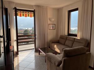 a living room with a couch and a large window at La Casa Sul Sasso in Dervio