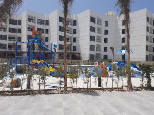 a playground in front of a building with palm trees at porto said بورتوسعيد in `Ezbet Shalabi el-Rûdi