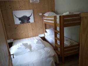 a bedroom with two bunk beds and a picture of a cow at Chalet de Xonrupt / Vue splendide sur les montagnes in Xonrupt-Longemer