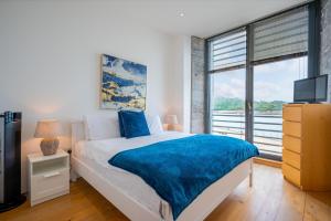 ein Schlafzimmer mit einem Bett und einem großen Fenster in der Unterkunft Royal William Yard Apartments in Plymouth