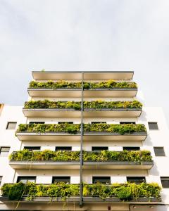 um edifício de apartamentos com plantas nas varandas em TreeTriana em Sevilha