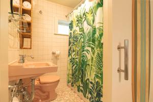 a bathroom with a toilet and a shower curtain at Rye Motor Inn - Oceanfront, Walk to Beach in Rye
