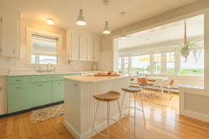a kitchen with white cabinets and a island with bar stools at RYE MOTOR INN - An Adults Only Hotel in Rye