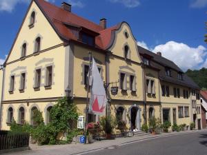een groot geel gebouw met een rood dak bij Hotel-Gasthof Die Post Brennerei Frankenhöhe in Schillingsfürst