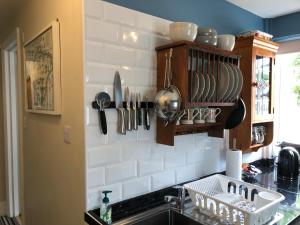 a kitchen with a sink and utensils on the wall at Little Treasure and Gem with private 2 person Hot Tub and up to 25 percent ferry saving in Shanklin