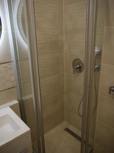 a shower with a glass door in a bathroom at Vízparti SAS Apartman Siófok in Siófok