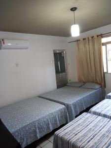 a room with two beds in a room with a window at Casa Rosarinho 1- RECIFE - Quartos com Banheiros Exclusivos in Recife