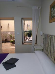 a bedroom with a bed and a window at Pension Azahar in Seville