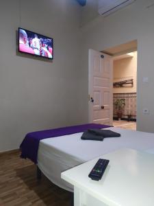 a bedroom with a bed with a remote control on it at Pension Azahar in Seville