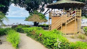 a gazebo with people sitting on it next to the ocean at Ecolodge Mar y Rio in Nuquí