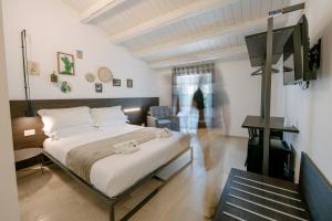 um quarto com uma cama grande e uma televisão em IBLA ROOMS em Ragusa