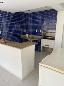 eine Küche mit blauen Fliesen an der Wand in der Unterkunft Apartamento Guarajuba in Camaçari