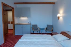 a hotel room with a bed and a kitchen with chairs at Plytu 9 apartment in Palanga
