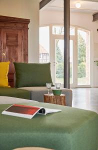 a living room with a green couch and a table at re~barn - Modern Country Stay in Essel