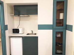 a small kitchen with a microwave and a sink at Hostellino in Naples