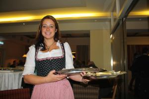 a woman is holding a tray of food at Chalets am Badesee Lassing in Lassing