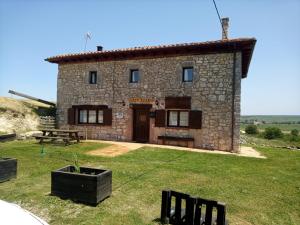 a stone house with a picnic table in front of it at El Rincón de Atapuerca in Atapuerca