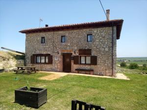 a stone house with a picnic table in front of it at El Rincón de Atapuerca in Atapuerca