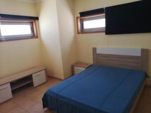 een slaapkamer met een blauw bed en 2 ramen bij Villa Arade Ferragudo in Ferragudo +31 foto's