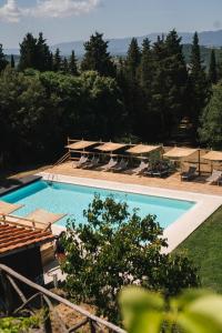 a pool with a pool table and chairs in it at Podere Castellare in Pelago