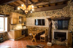 a kitchen with a table and a fireplace at CASA PITAXAN in Melide