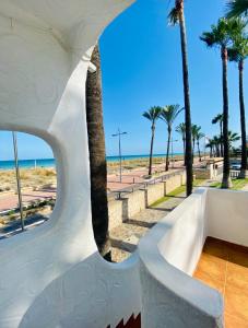 - une vue sur la plage depuis un bâtiment avec des palmiers dans l'établissement Apartamentos Tamarindos Peñiscola, à Peñíscola