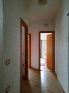 een lege kamer met 2 deuren en een tegelvloer bij Domo Vèdele in Galtellì