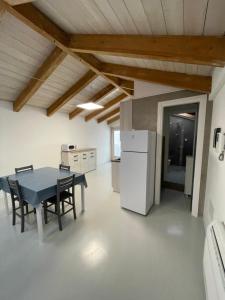 a kitchen and dining room with a table and a refrigerator at Loft Regina Margherita in SantʼAntìoco