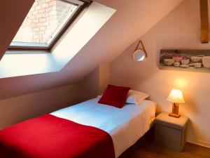 a attic bedroom with a bed and a window at Le Duplex ou l'Appart d'Agnès" in Honfleur