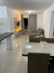 ein Wohnzimmer mit einem Sofa und einem Tisch in der Unterkunft Apartamento Guarajuba in Camaçari