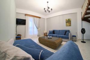 uma sala de estar com mobiliário azul e um sofá azul em Fedra Mare em Agios Stefanos
