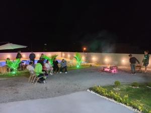 a group of people sitting around a fire at night at Pousada Morada dos Pássaros in Capitólio