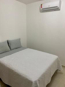 カマサリにあるApartamento Guarajubaのベッドルーム1室(ベッド1台、壁にエアコン付)