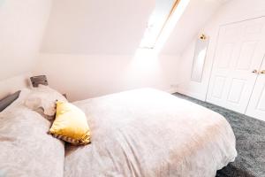 a bedroom with a white bed with a yellow pillow at Princes Street Apartment in Perth