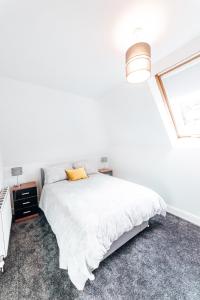 a white bedroom with a bed and a window at Princes Street Apartment in Perth