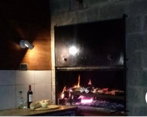 a kitchen with a stove with a fireplace at Casa en condominio in El Calafate