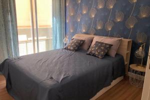 ein Schlafzimmer mit einem Bett mit blauen Wänden und einem Fenster in der Unterkunft Magnifique T3 Dans Une Résidence Au Centre De Toulon in Toulon