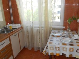 eine kleine Küche mit einem Tisch und einem Fenster in der Unterkunft Apartament Gabriela in Mangalia