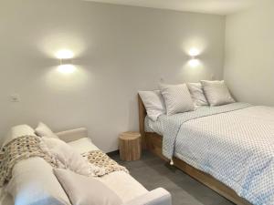 a bedroom with two beds and a couch and lights at STUDIO CONFORT & DETENTE in Chesières