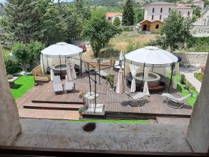 a wooden deck with chairs and umbrellas on it at B&B Palazzo La Loggia in Barisciano