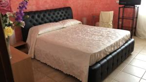 sypialnia z dużym łóżkiem z czarnym zagłówkiem w obiekcie Locazione in Appartamento sita in via Ponte di Ferro 2 b w mieście Gualdo Cattaneo