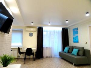 ein Wohnzimmer mit einem Sofa und einem Tisch in der Unterkunft Apart Gagarina 7 in Kropywnyzkyj