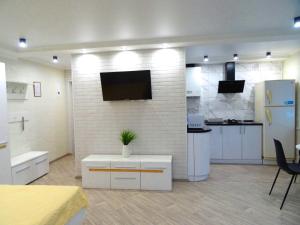 a kitchen with white appliances and a tv on a wall at Apart Gagarina 7 in Kropyvnytskyi
