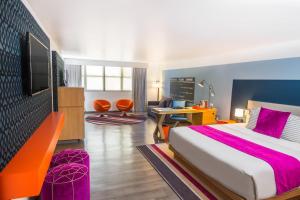 ein Hotelzimmer mit einem Bett und einem Fernseher in der Unterkunft TRYP by Wyndham Isla Verde in San Juan