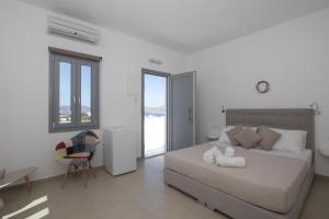 1 dormitorio con cama, escritorio y silla en Thira's Dolphin, en Akrotiri