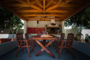 a wooden table and chairs on a patio at Marmaron Rooms in Agiokampos +42 photos