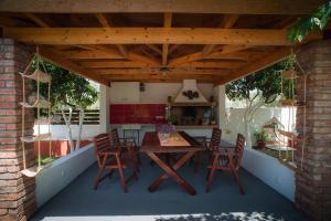 a patio with a table and chairs under a wooden roof at Marmaron Rooms in Agiokampos