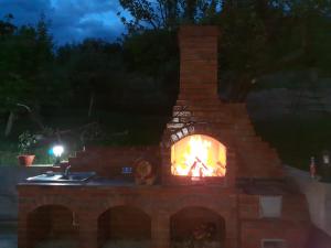 a brick fireplace with a fire in it at night at Casa Alex in Curtea de Argeş