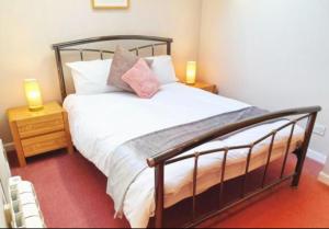 a bedroom with a bed with two lamps on tables at Stratton Cottage Guesthouse in Biggleswade