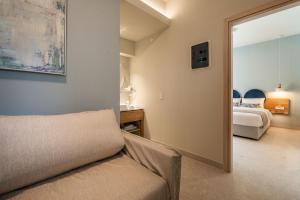 a living room with a couch and a bedroom at Syvota Gardens in Syvota